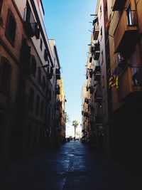 Alley amidst buildings in city against sky