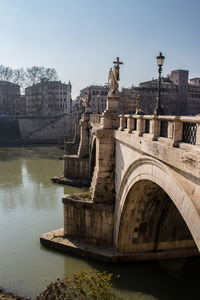 Arch bridge over river against buildings