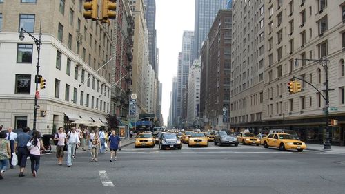 Vehicles on road amidst buildings in city