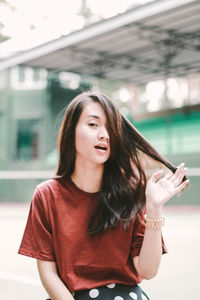 Portrait of beautiful woman standing against wall