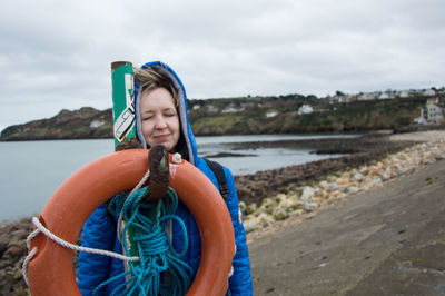 Young woman looking at sea against sky