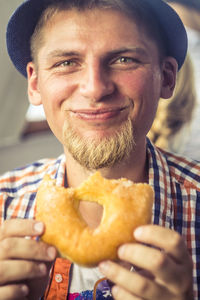 Portrait of smiling man holding donut