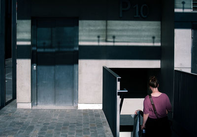 Rear view of a woman walking down stairs