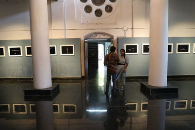 Rear view of people standing in corridor