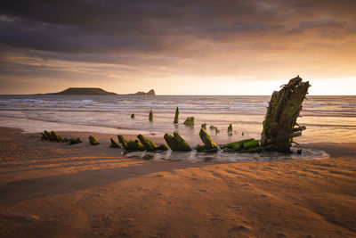 Scenic view of beach against sky during sunset