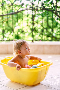 Cute girl sitting in bathtub