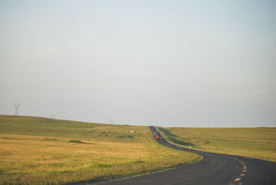 People walking on field against clear sky