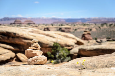 Stack of rocks on landscape against sky