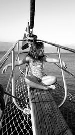 Woman in boat sailing on sea against clear sky