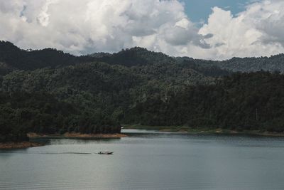 Scenic view of lake by trees against sky