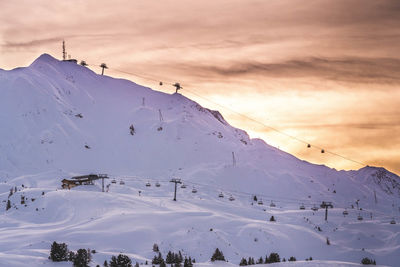 Scenic view of snow covered mountains against sky during sunset