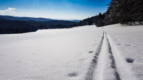 Tire tracks on snow covered landscape