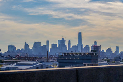 Modern buildings in city against cloudy sky