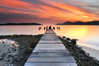Pier over sea against sky during sunset