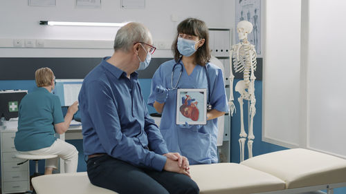 Side view of doctor examining patient in clinic