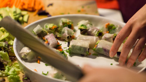 Cropped hand of person preparing food on table