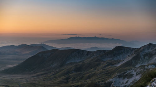 Scenic view of snowcapped mountains against sky during sunset