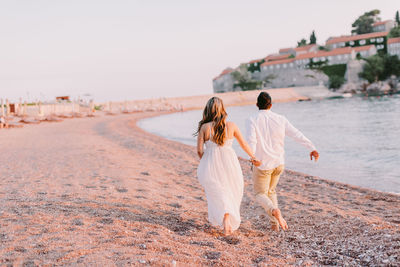 Rear view of women walking on beach