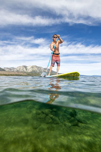 A man stand up paddle boarding on lake tahoe, ca