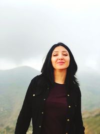 Portrait of a smiling young woman in fog