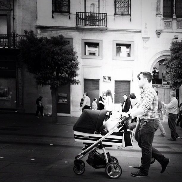 building exterior, bicycle, street, architecture, men, built structure, city, lifestyles, person, land vehicle, city life, transportation, walking, tree, mode of transport, leisure activity, full length, large group of people, road