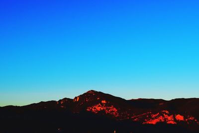 Scenic view of mountains against clear blue sky