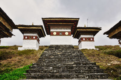 Low angle view of temple amidst buildings against sky