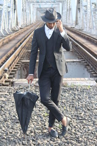 Full length of a man walking on railroad track