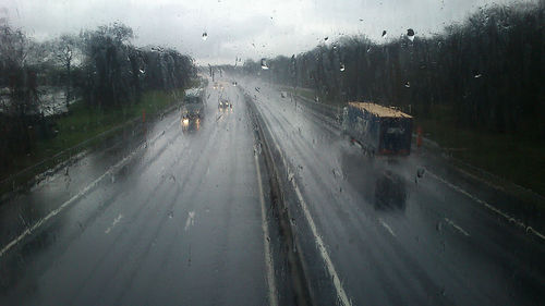 View of road seen through wet window