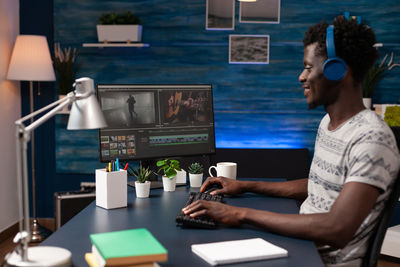 Side view of man using laptop at table