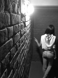 Girl leaning on brick wall