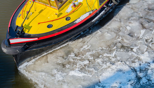 High angle view of boat at frozen lakeshore