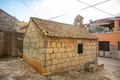 Old houses in town against sky