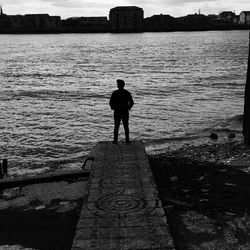 Silhouette of man standing in front of sea