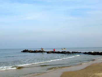 People on beach against sky