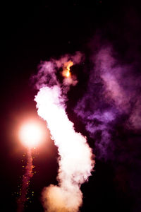 Low angle view of illuminated fireworks against sky at night