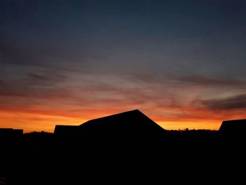 Low angle view of silhouette buildings against sky during sunset