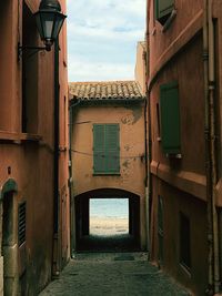 Alley amidst buildings in city against sky