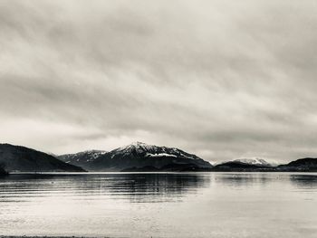 Scenic view of lake by mountains against sky
