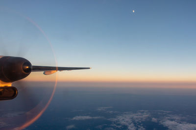 Airplane flying in sky during sunset