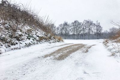 Snow covered landscape against clear sky