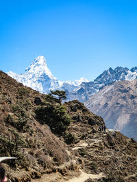 Scenic view of snowcapped mountains against clear blue sky