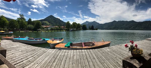 Boats moored on lake against sky