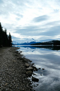 Scenic view of lake by snowcapped mountains against sky