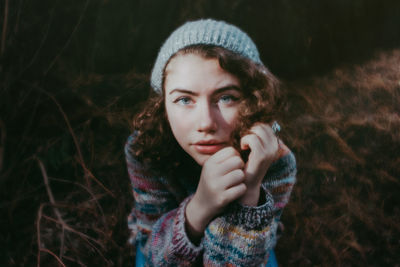 Girl in woods with hat and sweater on