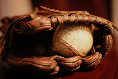 Close-up of baseball glove with ball on table