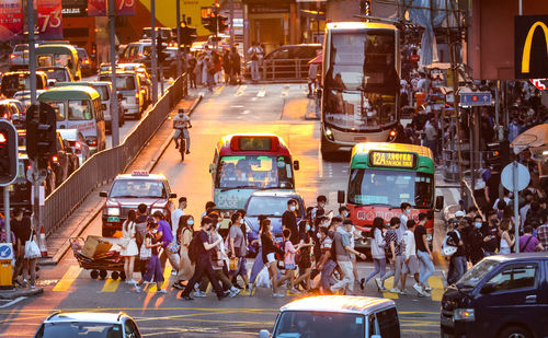 High angle view of people on busy city street at sunset 