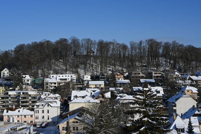 High angle view of snow covered trees and buildings against sky