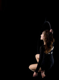 Low angle view of woman with ring against black background