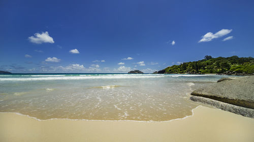 Scenic view of beach against blue sky